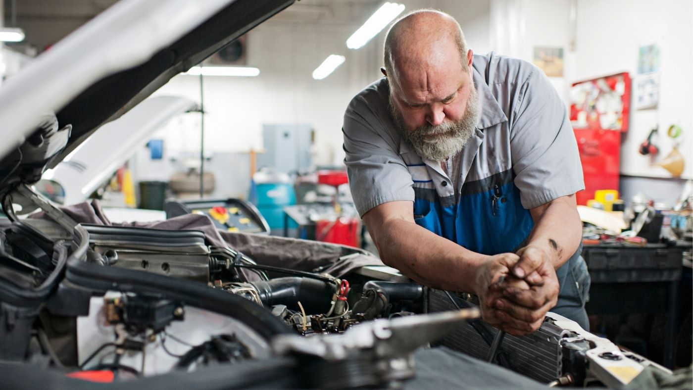 Male mechanic working on a car