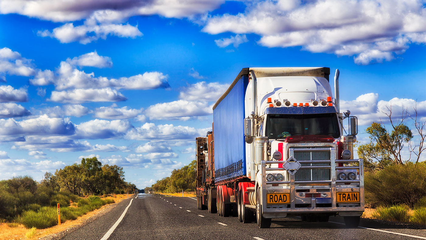 A truck on the open road on a sunny day.